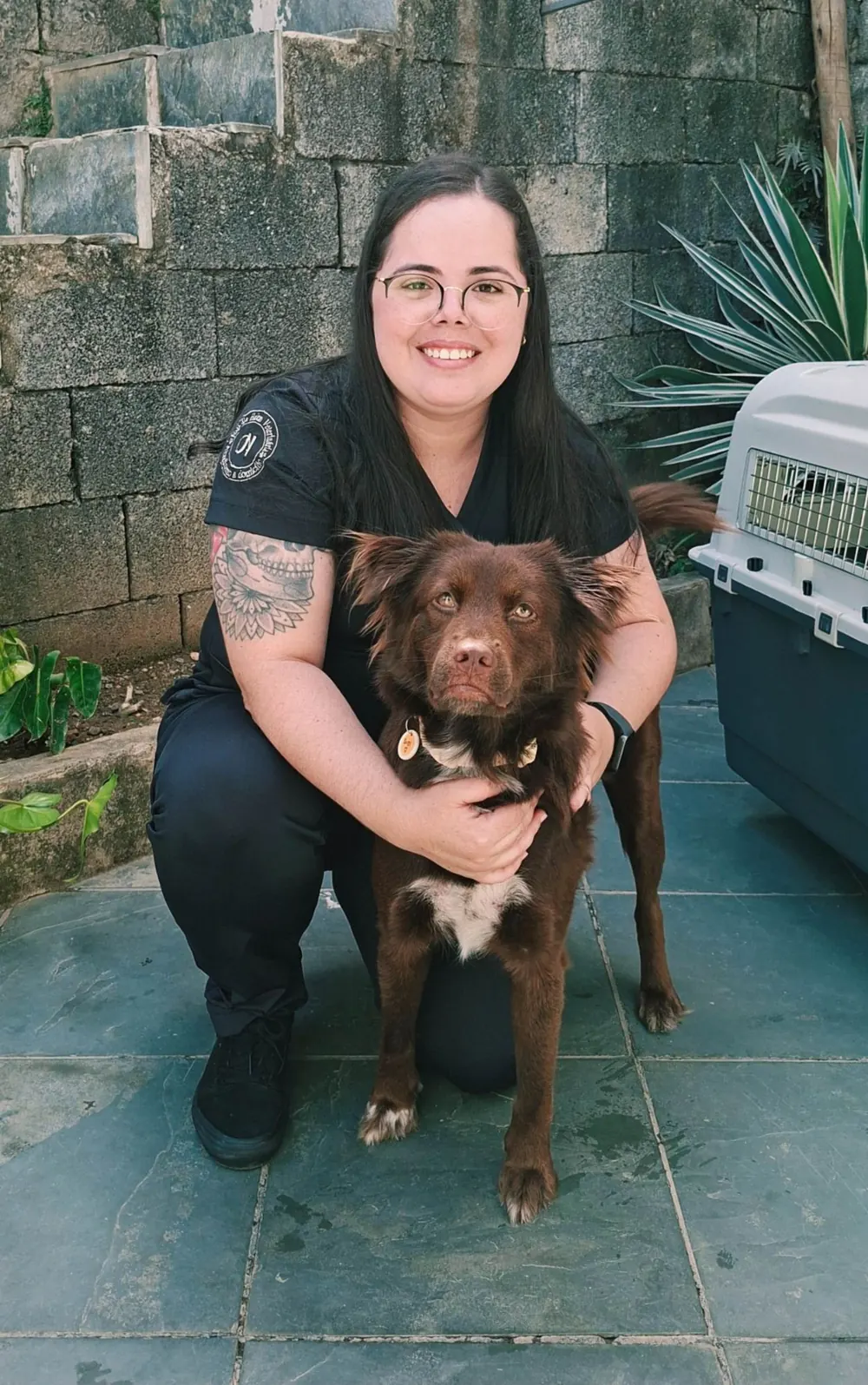 Dra. Nathalia Helen com um cão e uma caixa de transporte