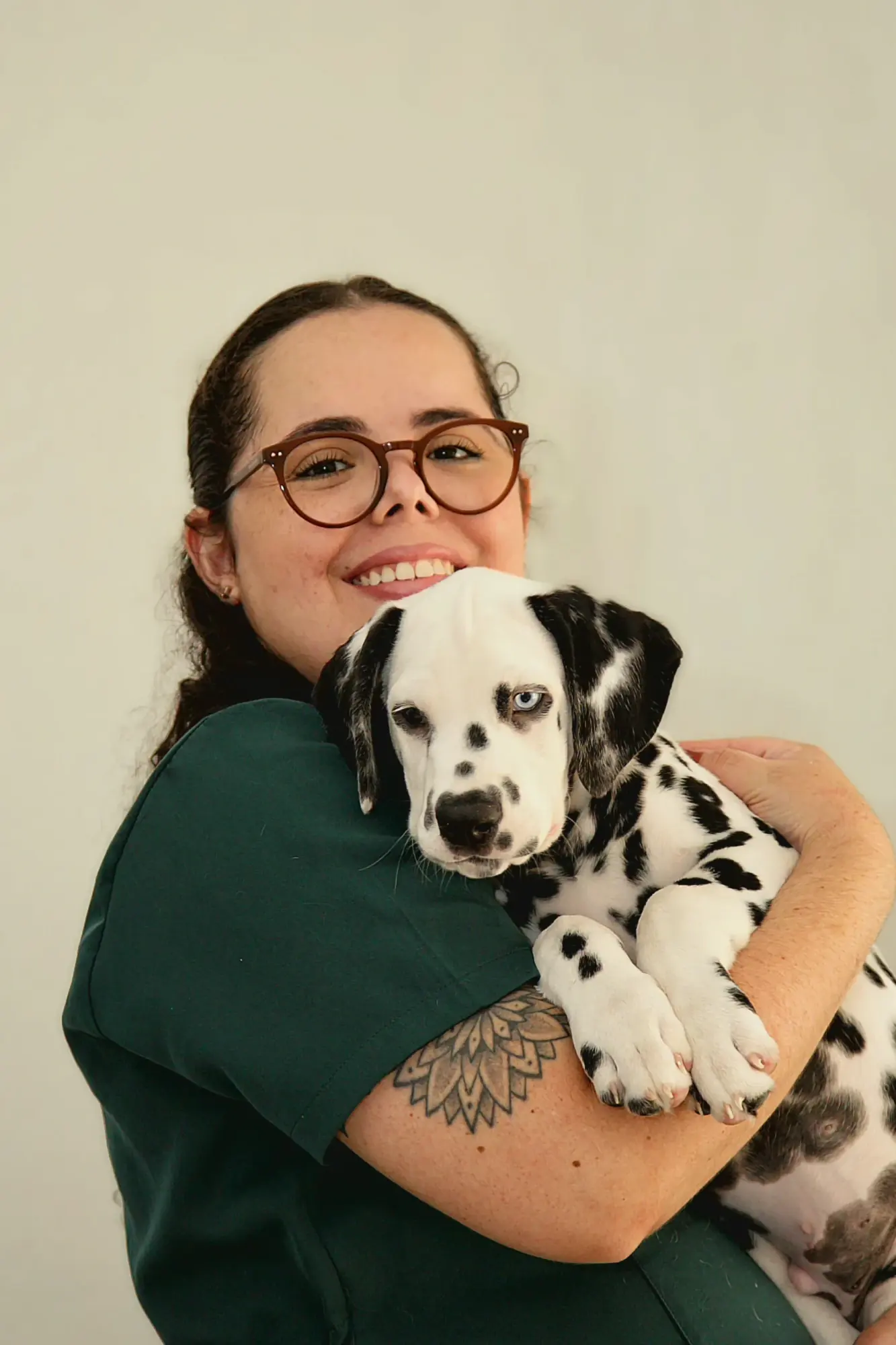 Dra. Nathalia Helen sorrindo com um filhote de dálmata no colo